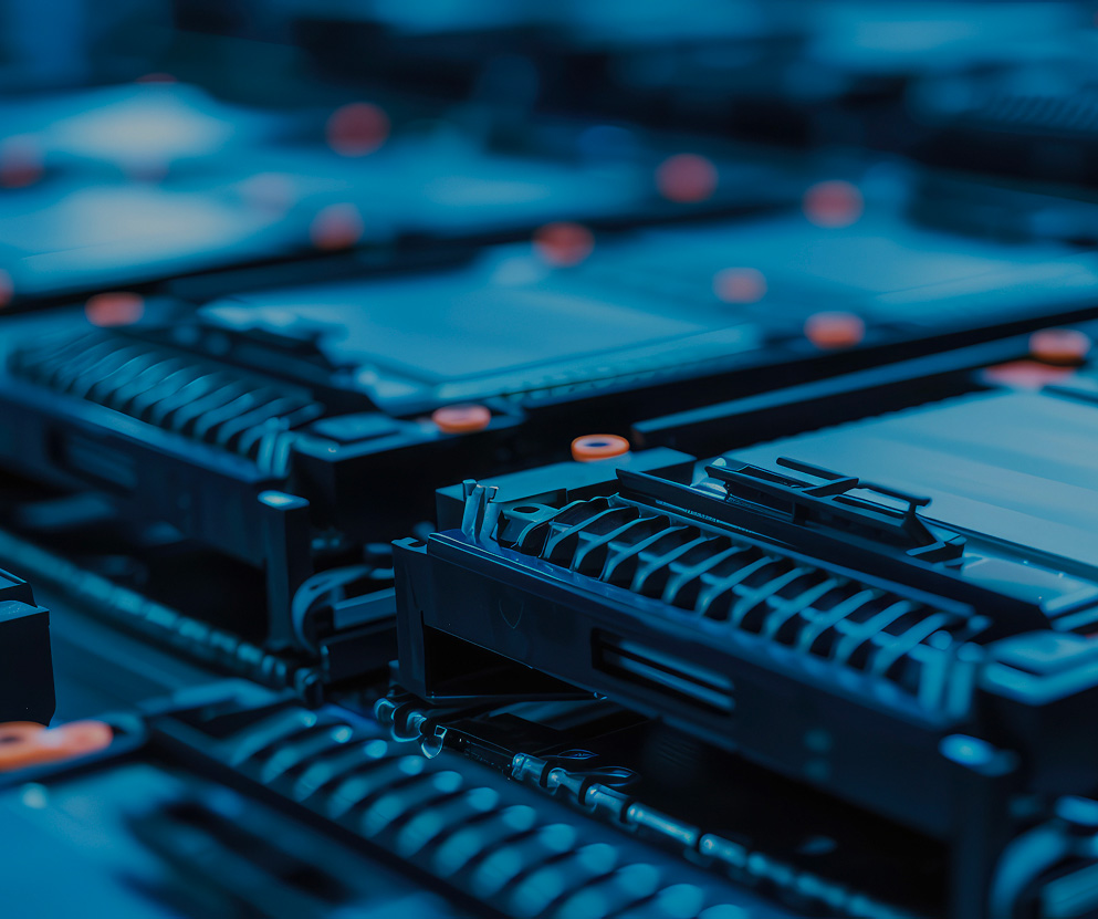 Close-up of lithium-ion battery modules arranged in a logistics facility, illustrating large-scale battery handling and energy supply chains. Desktop version of the visual for the homepage.